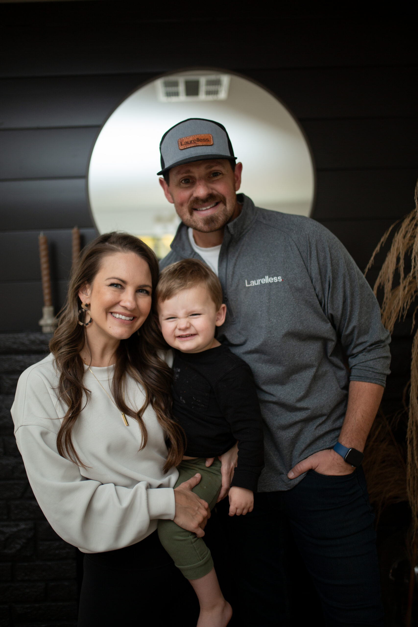 Laurelless founders, leaders, and husband-wife team pose with their son inside a recent home remodel